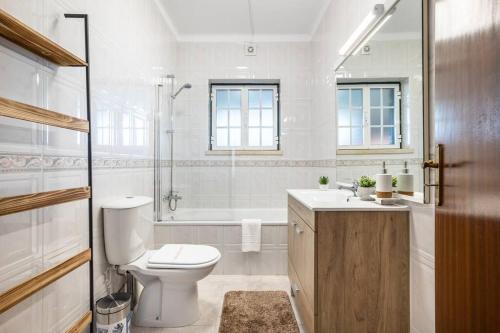 ein weißes Bad mit einem WC und einer Dusche in der Unterkunft Villa Coral - Private Heated Pool & Hot tub in Famalicão