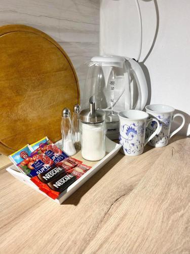 una mesa con cafetera y un libro y tazas en Apartmán Eden, en Bystrzyca