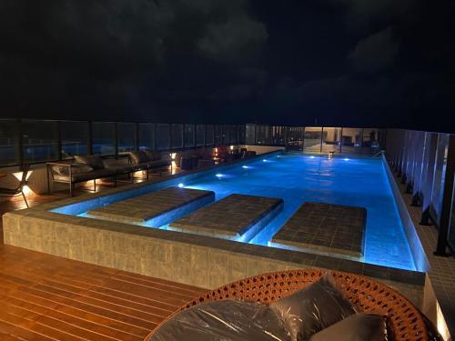 a swimming pool on top of a building at night at Lindo Flat no Jardim Oceania in João Pessoa