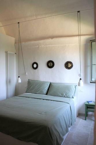 a bedroom with a bed with two clocks on the wall at Casa Ninetta, tra mare e natura. in Finale Ligure