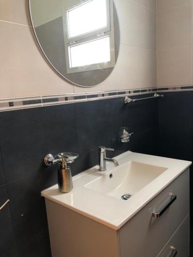 a bathroom with a sink and a mirror at CASA CAROTO in Porto Moniz