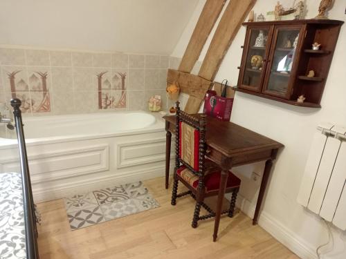 a bathroom with a tub and a table and a piano at Bergerie Bracquetuit in Bracquetuit