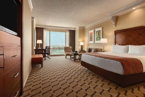 a hotel room with a bed and a large window at Horseshoe Bossier Casino & Hotel in Bossier City