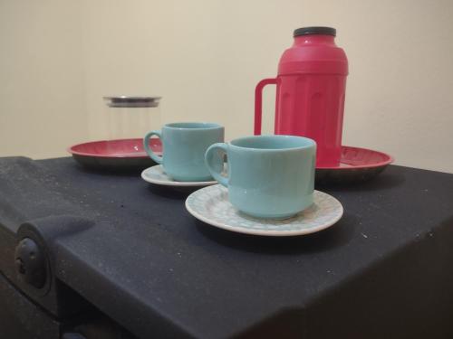 two cups and saucers on a table with a thermos at Studio 2 próximo ao Centro in Palmas