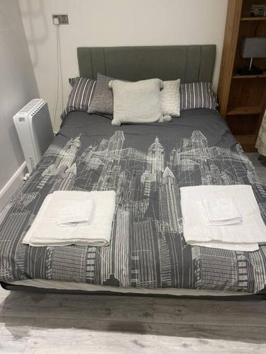 a bed with a blanket with a city on it at The Green Bus and the lodge in Woodstock