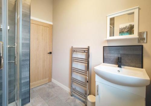 a bathroom with a sink and a shower at Lindsay House - South Manchester Stylish Townhouse With Free Parking in Manchester