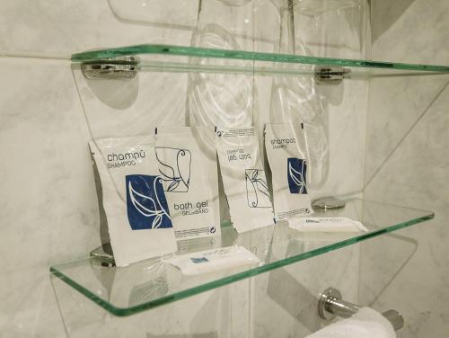 estante de cristal en el baño con artículos de aseo en Hostal Plaza, en Ciudad Rodrigo