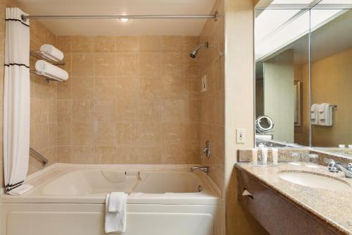 a bathroom with a tub and a sink at Horseshoe Bossier Casino & Hotel in Bossier City