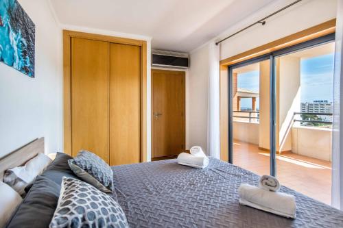 a bedroom with a bed with a couch and a balcony at Sunny and Bright Corcovada, T1 with Large Terrace, Albufeira in Albufeira