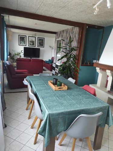 - une table à manger avec un tissu de table vert dans l'établissement Maison de village avec exterieur, à Oysonville