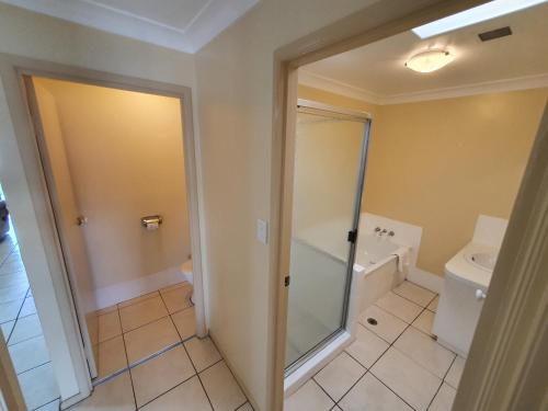 uma casa de banho com um chuveiro e um WC. em Grand Central Apartment em Toowoomba