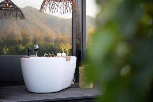 a bath tub sitting in front of a window at Vibo Wine Lodge At Viu Manent in Santa Cruz