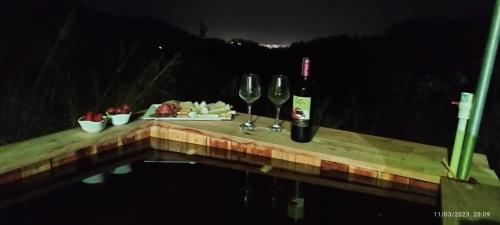 een tafel met twee glazen wijn en kaas bij Glamping MINKAWAY in Santa Marta