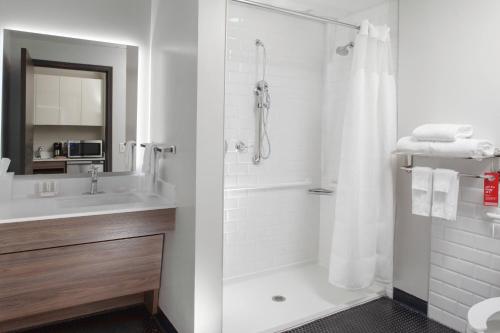 a white bathroom with a shower and a sink at Fairfield Inn & Suites by Marriott Dallas Downtown in Dallas