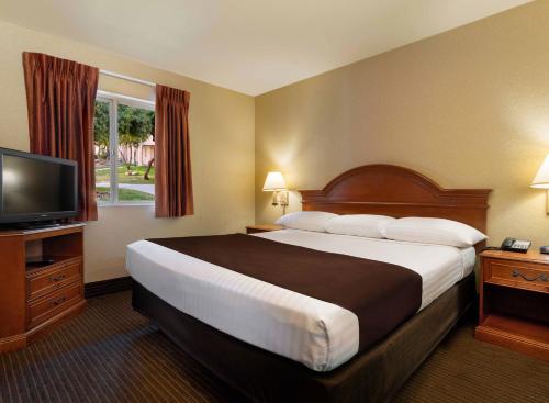 a hotel room with a large bed and a flat screen tv at Arizona Charlie's Boulder in Las Vegas