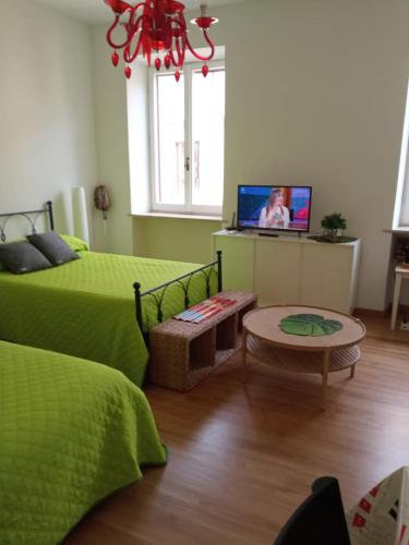 a bedroom with two beds and a tv in it at Forte Sangallo Home - PARKING POINT FOR BIKE in Civita Castellana