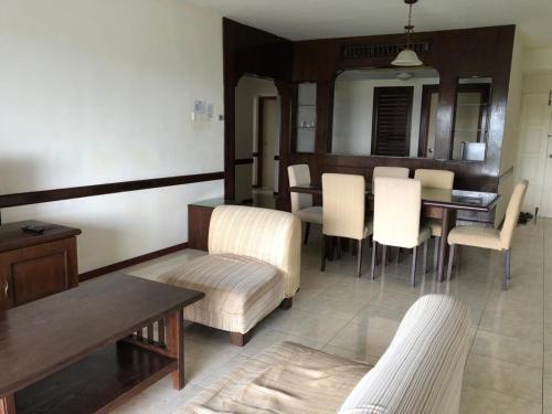 a living room with a table and white chairs at Aisis Home at Afamosa in Kampong Alor Gajah