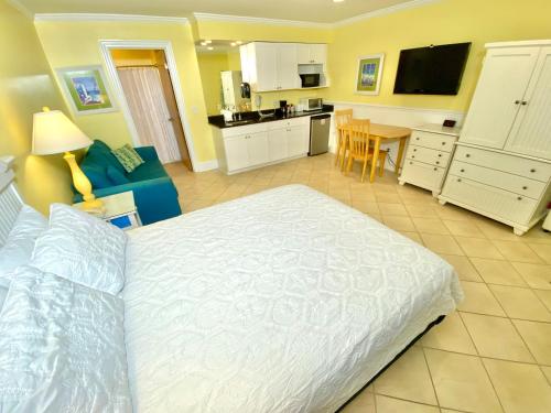 a bedroom with a white bed and a kitchen at Island Inn of Atlantic Beach in Atlantic Beach
