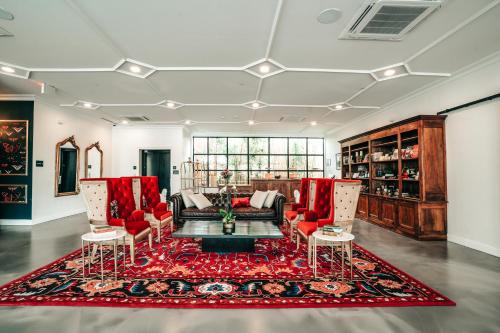 a living room with red furniture and a red rug at Colton House Hotel in Austin