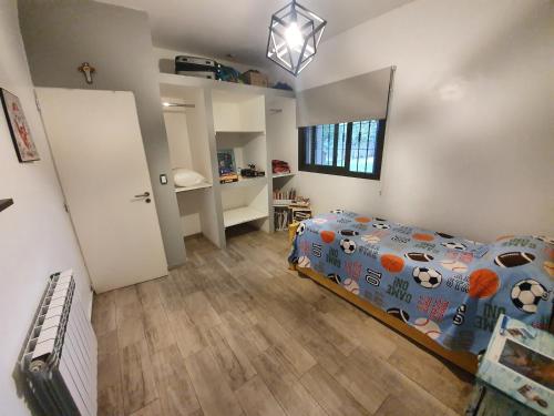1 dormitorio con 1 cama con edredón de temática futbolística en Casa al Pie de los Andes en Luján de Cuyo