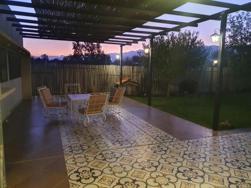 a patio with chairs and a table on a tile floor at Casa al Pie de los Andes in Ciudad Lujan de Cuyo