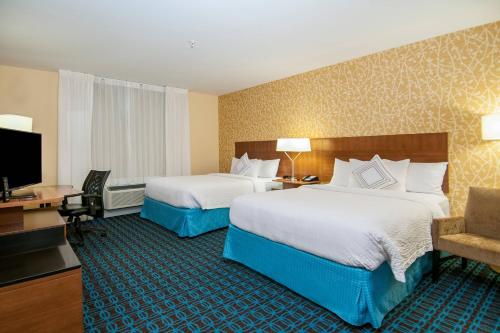 a hotel room with two beds and a desk at Fairfield Inn & Suites by Marriott Dallas Plano North in Plano