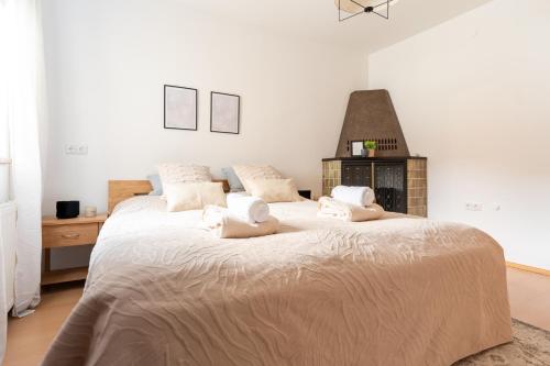 a white bedroom with a large bed with white sheets at Villa Venus in Willendorf in der Wachau