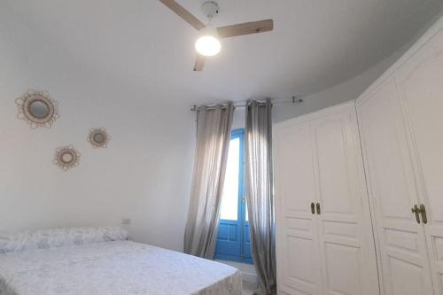 a white bedroom with a bed and a window at Villa Azul Beach in Piles