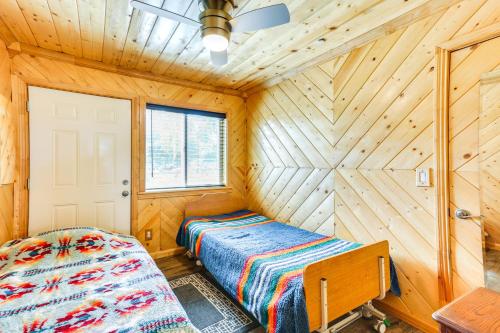a bedroom with two beds in a wooden room at Rustic California Vacation Rental with Rooftop Patio in Tulare