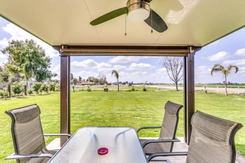 a table and chairs on a porch with a view of a field at Rustic California Vacation Rental with Rooftop Patio in Tulare