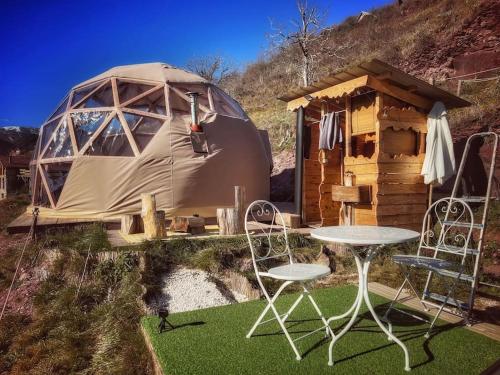 a yurt with a table and chairs in front of it at Les 3 Flocons Roure in Roure
