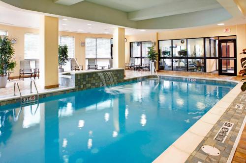 una gran piscina con agua azul en una habitación de hotel en Courtyard Pittsburgh Greensburg, en Greensburg