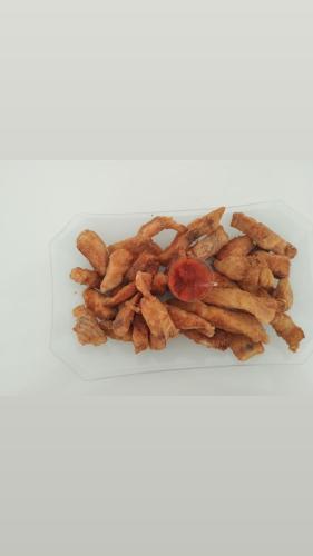 a plate of food with french fries and a tomato at Pousada Vida feliz in Águas de Lindóia