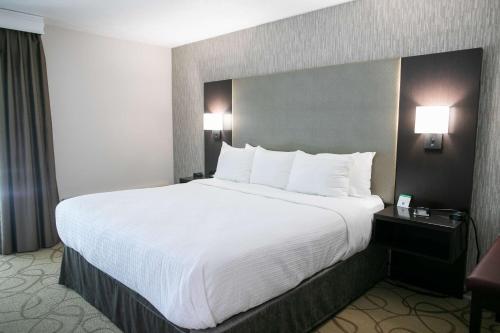 a large bed with white sheets and pillows in a hotel room at Best Western Plus Burley Inn & Convention Center in Burley