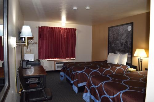 a hotel room with a bed and a desk and a window at AmeriVu Inn and Suites Shawano WI in Shawano