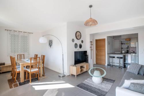 a living room with a table and a dining room at Appt lumineux et spacieux au cœur de Cannes in Cannes