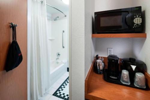 a kitchen with a microwave and a bathroom with a tub at Fairfield Inn & Suites by Marriott Austin Parmer Tech Ridge in Austin