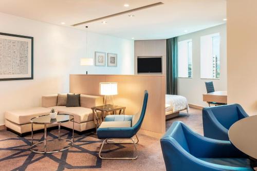 a hotel room with a couch and a table and chairs at Le Royal Meridien Abu Dhabi in Abu Dhabi