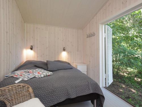 - une chambre avec un lit et une grande fenêtre dans l'établissement Holiday Home Lindehøjen, à Vejby