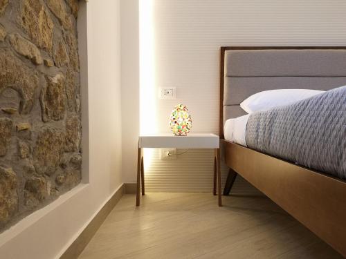 a bedroom with a bed and a side table with a lamp at Panorama Suite in Piazza Armerina