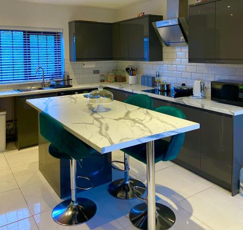 uma cozinha com uma ilha azul no meio em Warm welcoming Home em Manchester