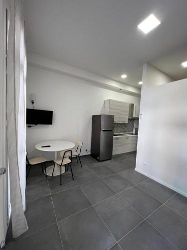 a kitchen with a table and a refrigerator at CasaCalzolari FIERA METEO TECNOPOLO BO in Bologna
