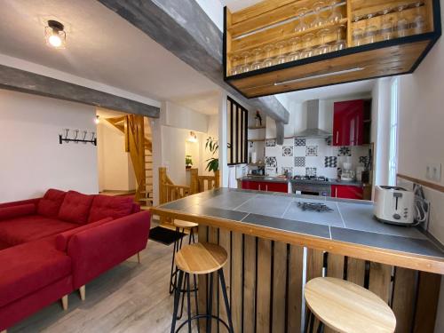 uma cozinha e uma sala de estar com um sofá vermelho em Faune em Saint-Aignan