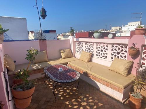 d'un canapé et d'une table sur un balcon. dans l'établissement Dar Sam - Red Room, à Rabat