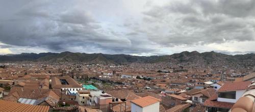 a view of a city with houses and mountains at Euro Hostal in Cusco