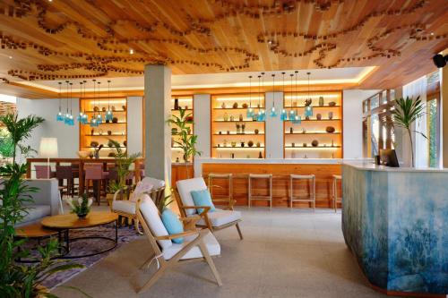 a lobby of a restaurant with chairs and a bar at laïla, Seychelles, a Tribute Portfolio Resort in Mahe