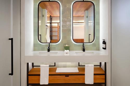 a bathroom with two sinks and two mirrors at laïla, Seychelles, a Tribute Portfolio Resort in Mahe