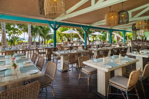 a restaurant on the beach with tables and chairs at laïla, Seychelles, a Tribute Portfolio Resort in Mahe