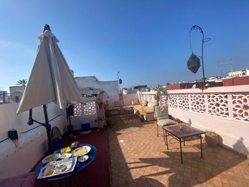 einen Balkon mit einem Tisch und Teller mit Lebensmitteln darauf in der Unterkunft Dar Sam - Pacha Room in Rabat