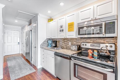 a kitchen with white cabinets and a stove top oven at Sunset Harbor Palms 2-304 in Navarre